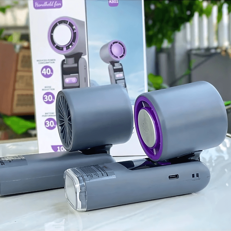 Close-up of grey handheld turbo fans with cooling technology placed in front of branded packaging box showing product specifications - techynook