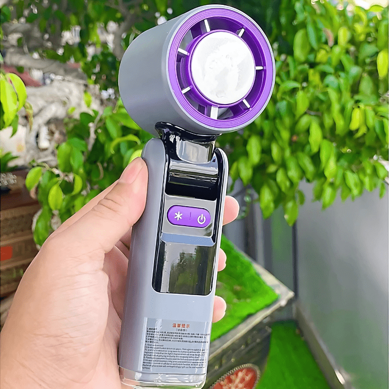 Handheld turbo fan held outdoors with purple cooling head and digital control buttons - techynook