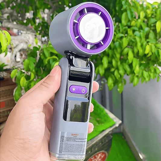 Handheld turbo fan held outdoors with purple cooling head and digital control buttons - techynook