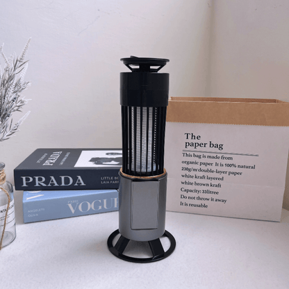 Stylish mosquito zapper lamp with modern base and USB-C charging, displayed on a desk with decor. Silent, portable, and safe for indoor use.