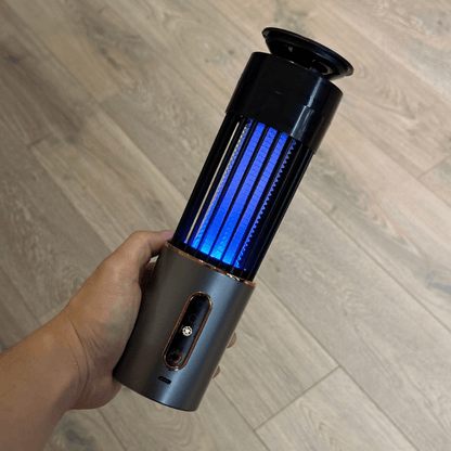 Hand holding portable mosquito zapper with UV light. Rechargeable electric insect killer for indoor and outdoor mosquito control, chemical-free and efficient.